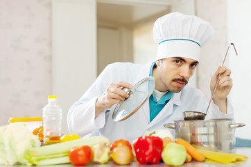 handsome cook tasting soup