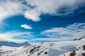 Obraz premium Snowy blue mountains in clouds
