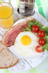 Scrambled eggs with bacon and vegetables served