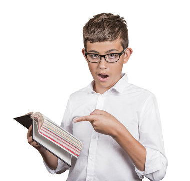 young man with glasses pointing at book page, shocked