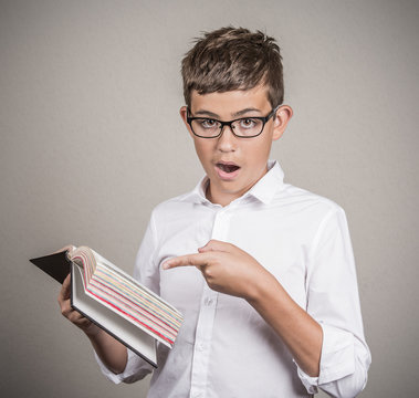 young man pointing at book page, shocked face expression