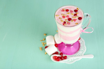 Cranberry milk dessert in glass  on color wooden background