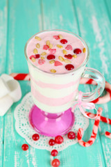 Cranberry milk dessert in glass  on color wooden background