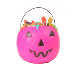 Pink plastic pumpkin filled with candy 