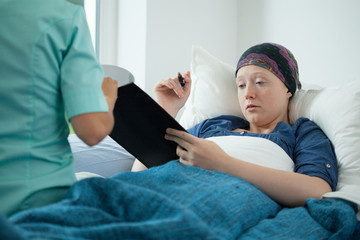 Cancer woman signing documents