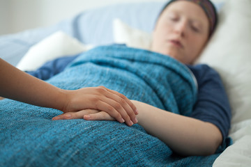 Nurse holding hand of ill woman