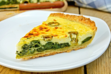 Pie with spinach and cheese in plate on table