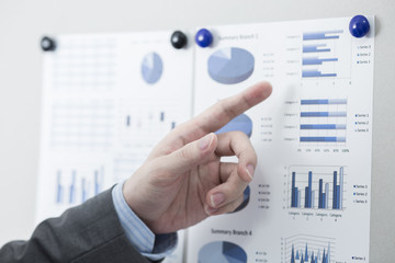 Businessman pointing to flip board with chart in office