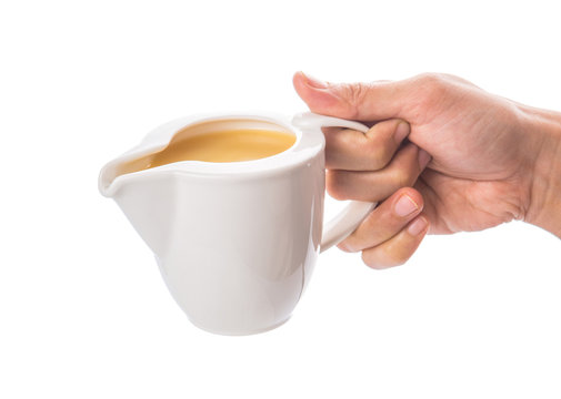 Female hand pouring condensed milk over white background