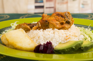 chicken served with white rice potato on a plate