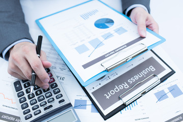 Close-up of graphs and charts analyzed by businessman