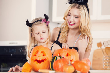 Kid on Halloween party making carved pumpkin with a little help 