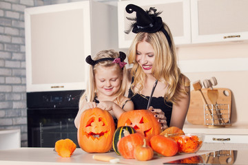 Kid on Halloween party making carved pumpkin with a little help 