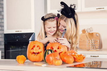 Kid on Halloween party making carved pumpkin with a little help 