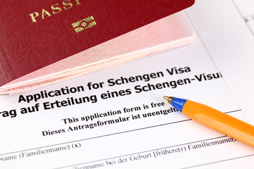 Application for Schengen visa, passport and pen.