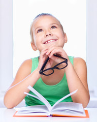 Little girl is reading a book