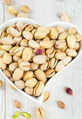 heart-shaped bowl full of pistachio nuts