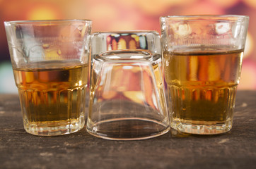 glass of rum whiskey over defocused lights background