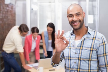 Happy businessman making okay gesture