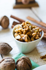 raw walnuts in a white bowl, white background