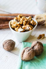 raw walnuts in a white bowl, white background