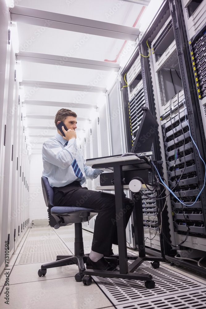 Aufkleber technician talking on phone while diagnosing servers