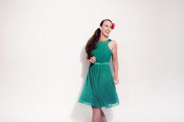 Retro fifties brunette fashion woman wearing red flower and gree