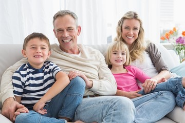 Obraz premium Portrait of a smiling family sitting on sofa