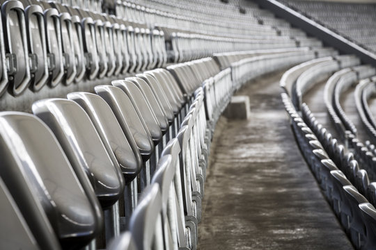 some rows of gray stadium seats, shoot from the side