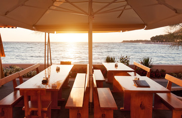 terace restaurant tables under parasol at sunset
