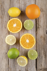 Fototapeta na wymiar orange, lemon and lime on rustic wood