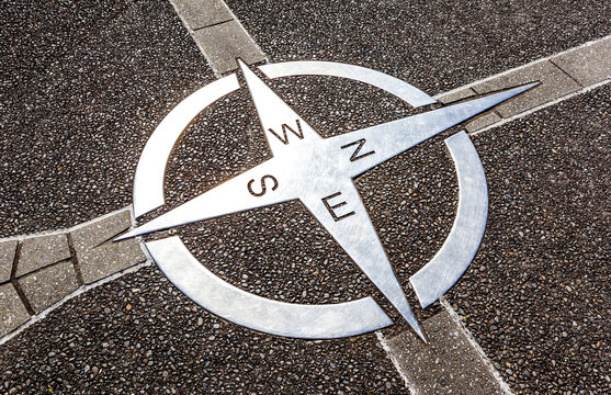 Decorative compass on the cement ground.