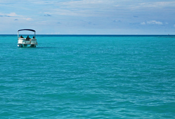 Fototapeta premium A single pontoon boat in a calm tropical sea