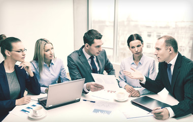 business team with laptop having discussion