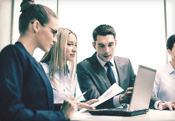 business team with laptop having discussion