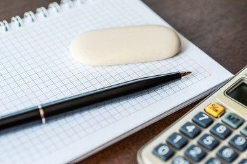 Calculator with a pen and eraser on the table