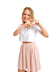 Girl making a heart with her hands over white background