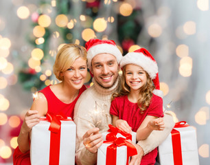 happy family in santa helper hats with gift boxes