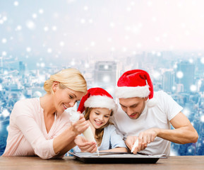 happy family in santa helper hats cooking