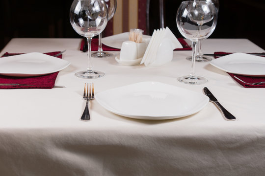 Empty white plate in a formal table setting