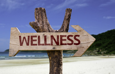 Wellness wooden sign with a beach on background