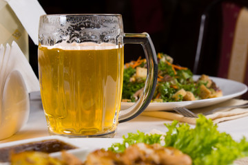 Mug of Beer on Table Amongst Plates of Food