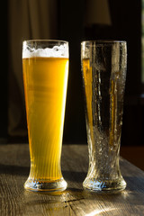 Glass of Beer Beside Empty Glass on Table