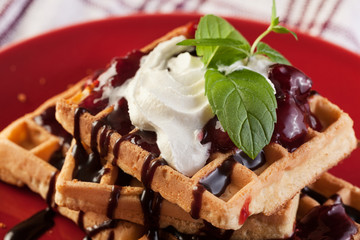 Waffles with chocolate sauce, whipped cream and confiture