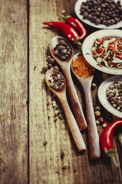 Three wooden spoons with spices and chili peppers