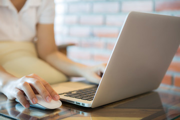 Closeup of business woman hand typing on laptop keyboard with mo