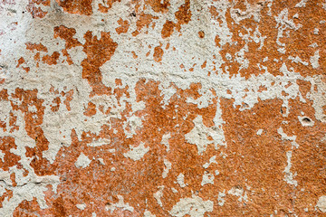 Concrete surface with the remains of whitewash and orange paint