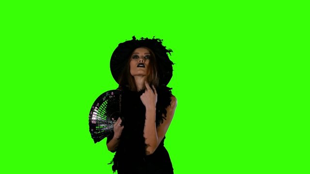 Halloween witch with black fan on green screen