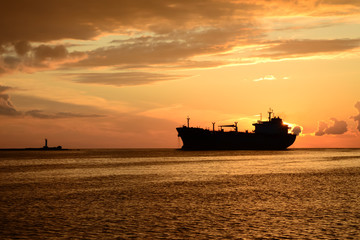 sunset at pier and a passing ship