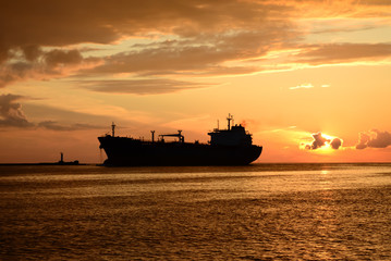 Fototapeta premium sunset at pier and a passing ship